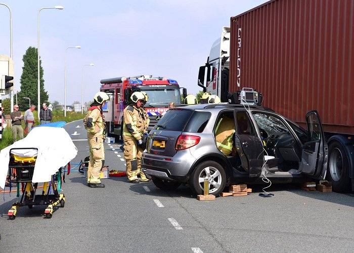 Maasdijk Auto komt onder een trailer van vrachtwagen op de Maasdijk 's ... photo